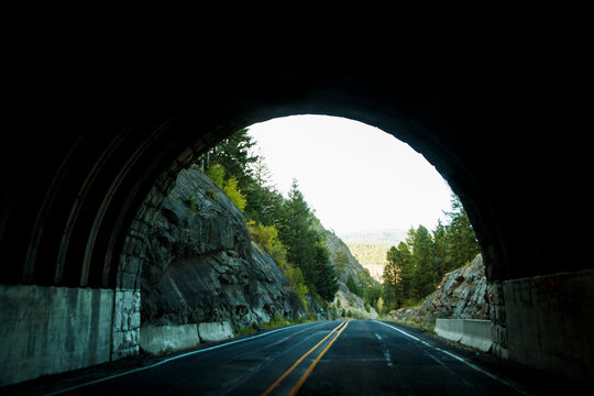 The view of the end of a road tunnel from the highway.
