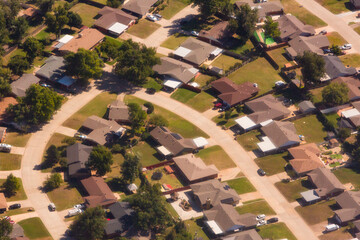 A residential area, an aerial view of the houses, layout and gardens and the roads.