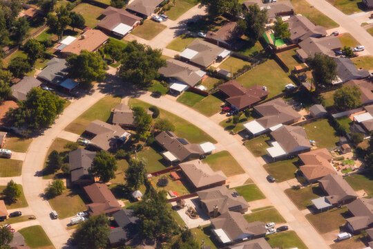 A residential area, an aerial view of the houses, layout and gardens and the roads.