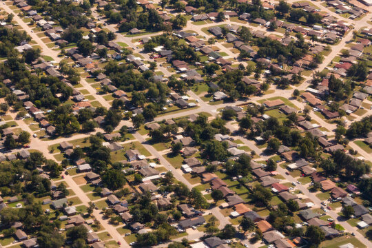 A residential area, an aerial view of the houses, layout and gardens and the roads in a grid pattern.