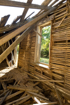 A dilapidated building, a ruin with timbers falling from the roof.