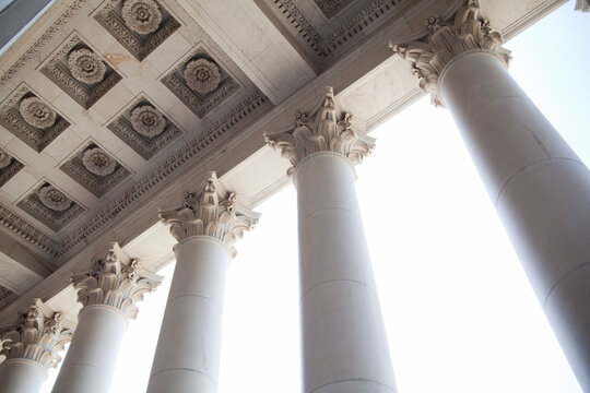 The American Capitol Building, a low angle view of the tall columns with gilded carved stonework capitals, and coffered ceiling.