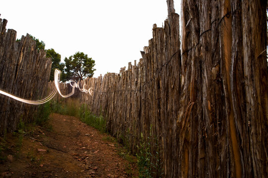 Light Painting, a trail of light winding along a fence by a narrow path.