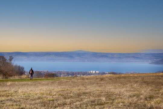 Wanderer auf einer Wiese &uuml;ber einem See