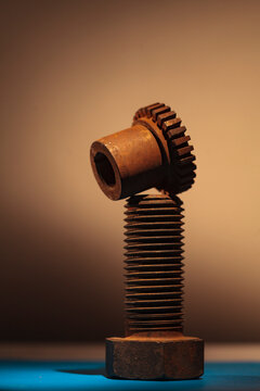 A large upright bolt with a thread and a bolt with cog notches.