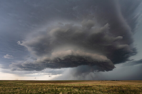 Developing Mesocyclone, a towering two layer shape above the horizon, storm clouds above the horizon.