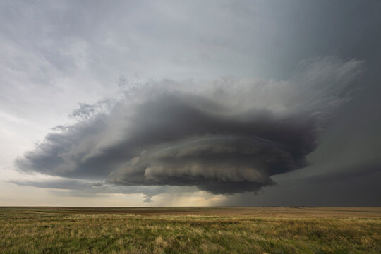 Developing Mesocyclone, a towering cloud shape above the horizon, fields.
