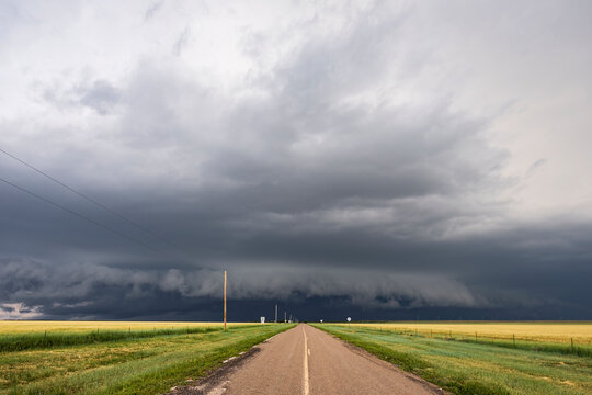 Developing Supercell storm on the horizon, black clouds at the end of a highway.