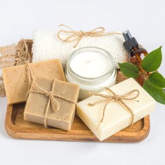 A rustic wooden tray elegantly displays an assortment of artisanal soaps in various colors and shapes, alongside beautifully crafted scented candles.
