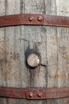 Detailed view of a weathered wooden barrel with cork, secured with rusted iron bands, Hill City, South Dakota.