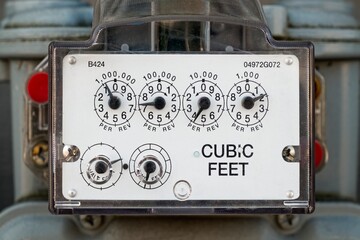 Detailed view of a natural gas meter with dials measuring cubic feet of gas usage for residential or commercial energy monitoring.