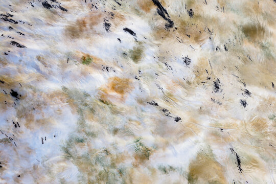 Long exposure of moving water, churning and flowing, surface highlights, impressionistic blurred effect. 