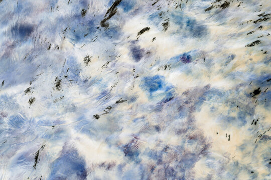 Long exposure of river water flowing, continuous motion, blue, white and grey colours.
