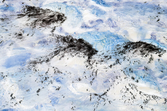 Long exposure of river water flowing over boulders and rocks, abstract impressionist effect, blue, white and grey colours.