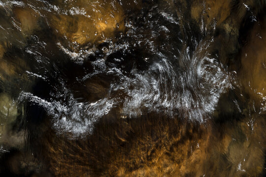 River water abstract, long exposure of river water flowing over boulders and rocks
