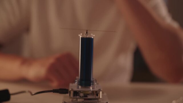 Scientist conducting tesla coil experiment, high-voltage arcs wirelessly lighting leds, demonstrating electromagnetic induction, energy transfer and physics in dark lab setting, close-up, slow motion.