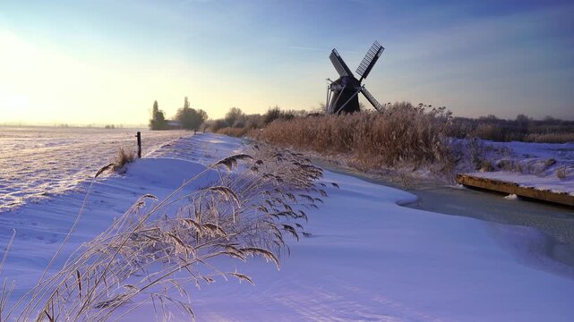 Winter sunrise at a windmill in the Dutch countryside.