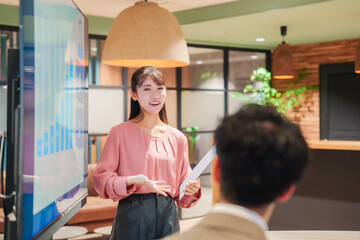 モダンオフィスでプレゼンをする若い女性