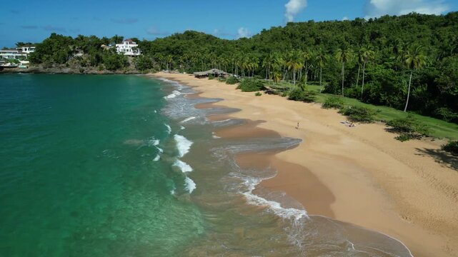 Long overhead float revealing the pristine beach extending into turquoise sea.