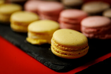 Colorful macarons arranged on black serving board