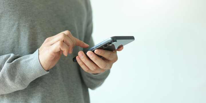 close up businessman hand hold smartphone to surfing the internet and check work or mail on website while sit in the living room in weekend for business technology and lifestyle concept