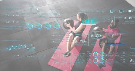 Pair in workout clothes exercising in gym, holding medicine balls on red mats with hologram charts
