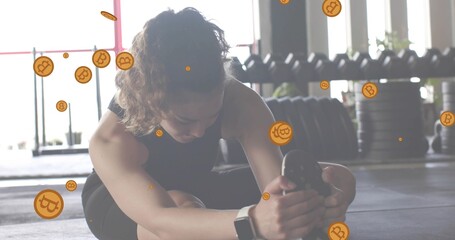 Stretching female athlete holding right foot at gym, wearing black athletic wear, Bitcoin overlays