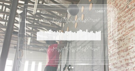 Pulling up male in red top and black shorts at industrial gym, gripping pull-up bar, HUD