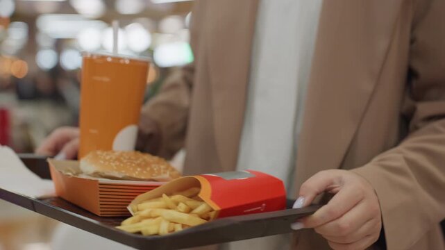 fast meal pick, efficient professional chooses quick bite, busy shopper grabs rapid meal during midday rush, individual seeking speedy lunch amidst lively hustle of crowded shopping center