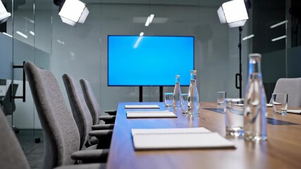 Empty conference room with blue screen background. Modern office interior setup for chroma key video production and virtual meetings. Studio footage for business presentations.