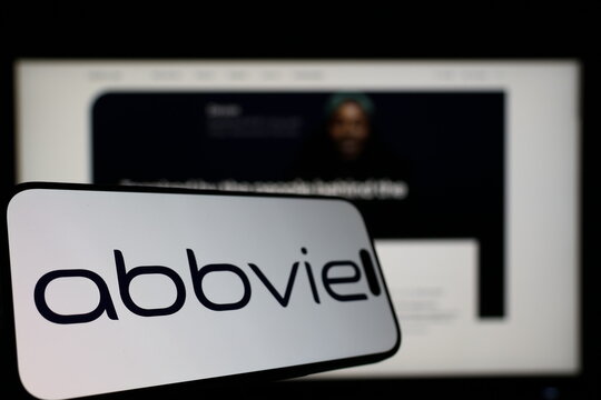 Kiel, Germany - 01-12-2026: Smartphone displaying AbbVie logo in front of the company website on a monitor