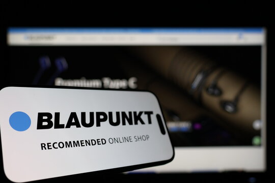 Kiel, Germany - 01-12-2026: Smartphone displaying Blaupunkt logo in front of the company website on a monitor