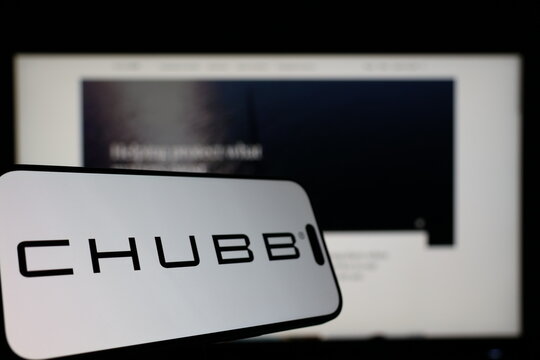 Kiel, Germany - 01-12-2026: Smartphone displaying Chubb logo in front of the company website on a monitor