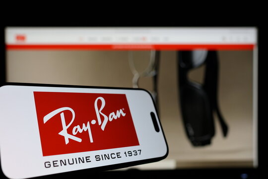 Kiel, Germany - 01-12-2026: Smartphone displaying Rayban logo in front of the company website on a monitor