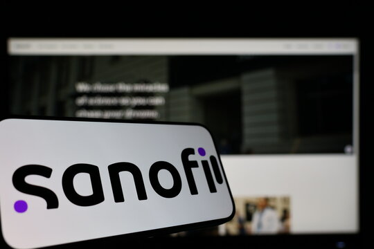 Kiel, Germany - 01-12-2026: Smartphone displaying Sanofi logo in front of the company website on a monitor