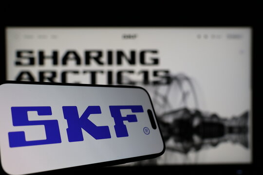 Kiel, Germany - 01-12-2026: Smartphone displaying SKF logo in front of the company website on a monitor