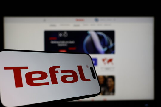 Kiel, Germany - 01-12-2026: Smartphone displaying Tefal logo in front of the company website on a monitor