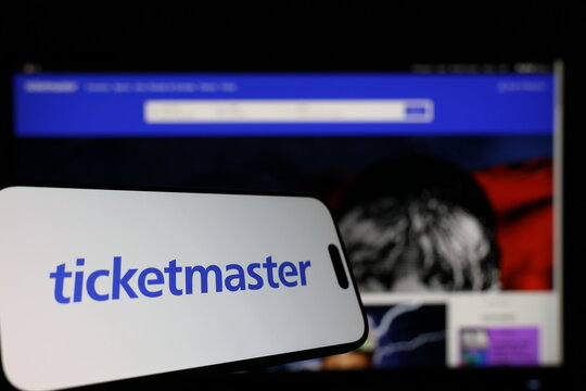 Kiel, Germany - 01-12-2026: Smartphone displaying Ticketmaster logo in front of the company website on a monitor