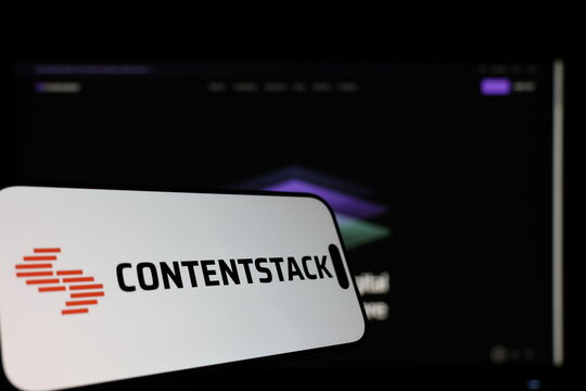 Kiel, Germany - 01-12-2026: Smartphone displaying Contentstack logo in front of the company website on a monitor