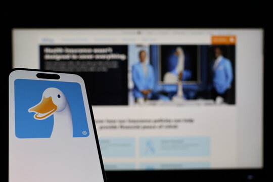 Kiel, Germany - 01-12-2026: Smartphone displaying Aflac logo in front of the company website on a monitor