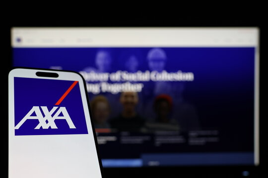 Kiel, Germany - 01-12-2026: Smartphone displaying AXA logo in front of the company website on a monitor