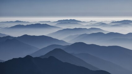 Fototapeta premium A layered, misty mountain range fades into the distance, with a light sky above