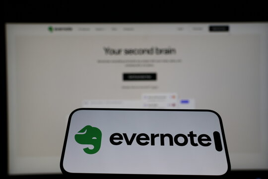 Kiel, Germany - 01-12-2026: Smartphone displaying Evernote logo in front of the company website on a monitor