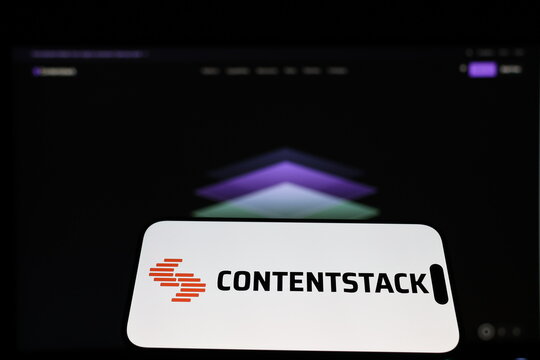 Kiel, Germany - 01-12-2026: Smartphone displaying Contentstack logo in front of the company website on a monitor