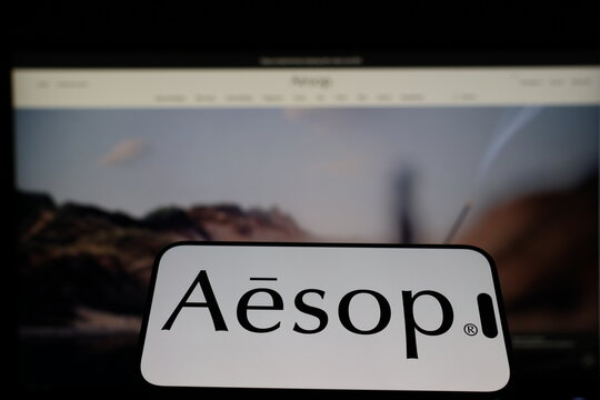 Kiel, Germany - 01-12-2026: Smartphone displaying Aesop logo in front of the company website on a monitor