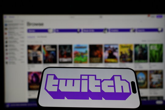 Kiel, Germany - 01-12-2026: Smartphone displaying Twitch logo in front of the company website on a monitor