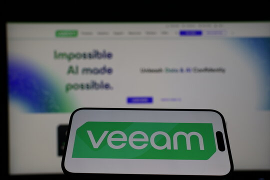 Kiel, Germany - 01-12-2026: Smartphone displaying Veeam logo in front of the company website on a monitor