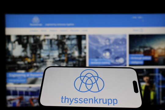 Kiel, Germany - 01-12-2026: Smartphone displaying thyssenkrupp logo in front of the company website on a monitor