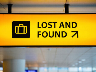 Lost and found sign with yellow and black colors and suitcase icon indicating airport or travel location information board
