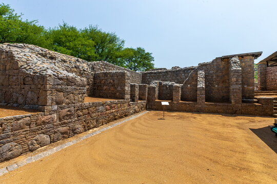 View of ancient stone ruins standing steadfast against the azure sky, with warm golden sand blanketing the grounds, a timeless tableau, Taxila, Khyber Pakhtunkhwa, Pakistan.